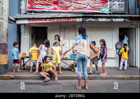 De jeunes enfants philippins jouent dans la rue de la vieille ville fortifiée d'Intramuros, Manille, Philippines. Banque D'Images