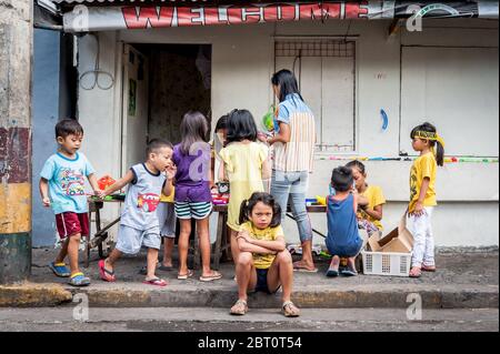 De jeunes enfants philippins jouent dans la rue de la vieille ville fortifiée d'Intramuros, Manille, Philippines. Banque D'Images