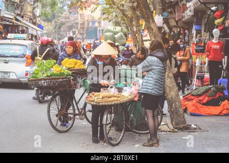 Hoi an, Vietnam - 7 février 2018 : les femmes vendent des fruits et légumes tôt le matin dans une rue animée, Hanoi, Vietnam Banque D'Images