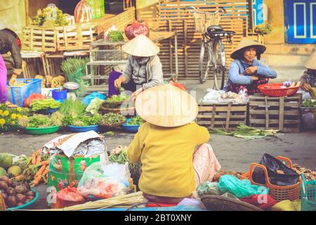 Hoi an, Vietnam - 7 février 2018 : attention douce sur la femme vietnamienne qui vend des légumes sur un marché en bord de route à Hoi an, province de Quang Nam, Vietnam. Banque D'Images