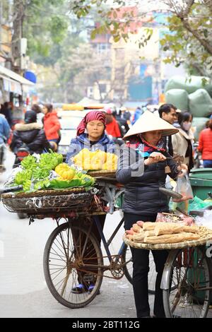 Hoi an, Vietnam - 7 février 2018 : les femmes vendent des fruits et légumes tôt le matin dans une rue animée, Hanoi, Vietnam Banque D'Images