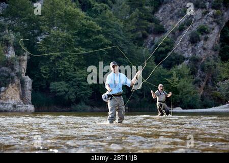 Deux pêcheurs à la mouche lancent des lignes de pêche héritière dans la rivière Ulugüney, près du château de la ruine Alar Kalesi en Turquie. Banque D'Images