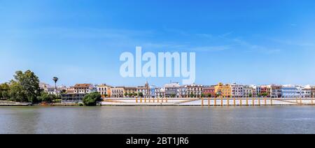 Maisons colorées du quartier de Triana (rue Betis) sur le fleuve Guadalquivir près du pont de Triana à Séville, Espagne. Banque D'Images