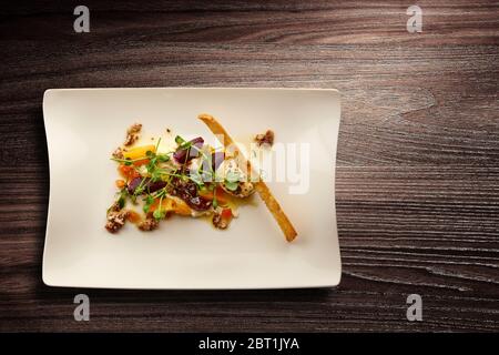 Directement au-dessus d'une nouvelle assiette de cuisine élégante avec salade de betteraves et de noix sur fond de bois Banque D'Images