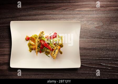 Directement au-dessus d'une nouvelle assiette de cuisine élégante de légumes grillés sur fond de bois Banque D'Images