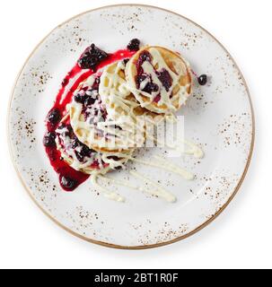 Crêpes au fromage cottage ou beignets de caillé décorés de myrtilles dans une assiette sur table blanche vue sur le dessus. Petit déjeuner sain et diététique. Vue de dessus. Banque D'Images