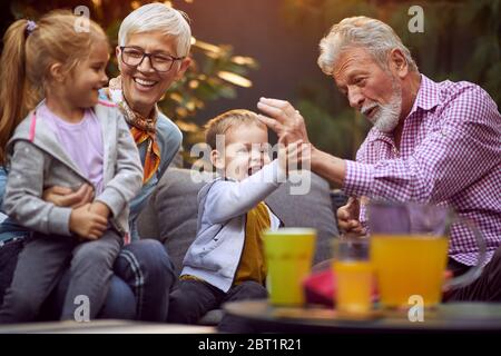 Petits-enfants joyeux passer du bon et drôle de temps avec leurs heureux grands-parents. Banque D'Images