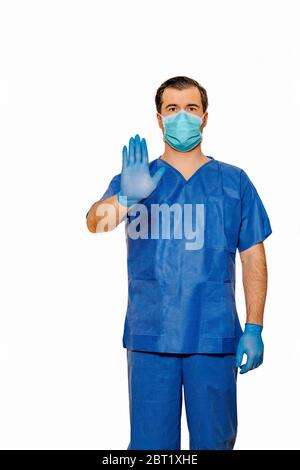 Un médecin masculin se frotte avec un masque facial et des gants de protection et montre un panneau stop avec sa main et sa paume. Fond blanc Uni. Concept de coronavirus Banque D'Images