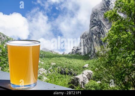 Verre de bière légère avec vue sur les montagnes en Croatie. Belle vue sur les rochers, la forêt et le ciel bleu dans le parc national de Paklenica, les montagnes Velebit. Banque D'Images