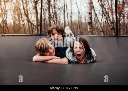 Trois enfants jouant sur un trampoline, USA Banque D'Images