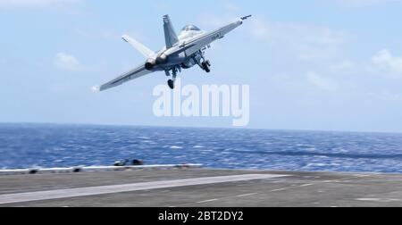 Mer des Philippines, États-Unis. 22 mai 2020. Un avion de chasse F/A-18F Super Hornet de la marine américaine, affecté aux Chevaliers noirs de VFA 154, sort du pont de vol du porte-avions de la classe Nimitz USS Theodore Roosevelt le 22 mai 2020 en mer des Philippines. L'équipage COVID-NEGATIVE est revenu de la quarantaine et le navire a poursuivi son déploiement prévu dans l'Indo-Pacifique. Crédit : MCS3 Conner Blake/États-Unis Navy/Alay Live News Banque D'Images