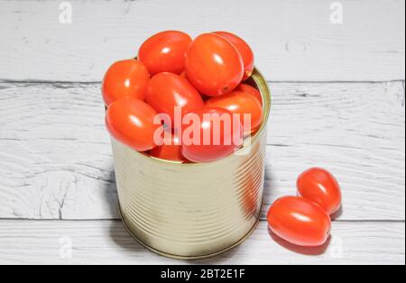 Tomates cerises rouges fraîches dans une boîte sur fond de bois. Banque D'Images