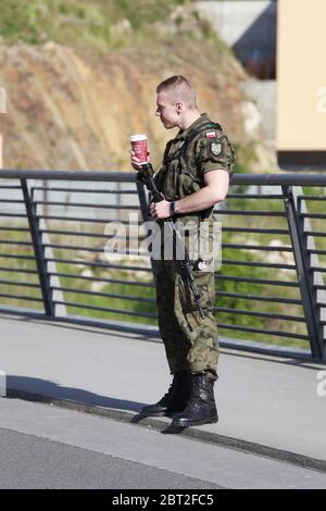 ein mit Maschinengehr bewaffneter polnischer Grenzschützer unterhält sich mit einer Frau an der Altstadtbrücke in Zgorzelec am 22.5.2020 Banque D'Images