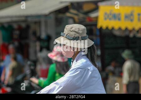 Femme avec capuchon de bouche au moteur à Hanoi, Vietnam Banque D'Images