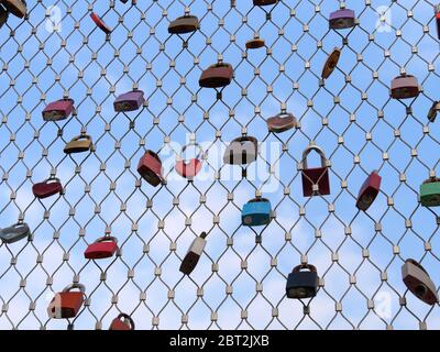 Beaucoup de cadenas d'amoureux accrochant sur les rails de pont contre le ciel bleu Banque D'Images