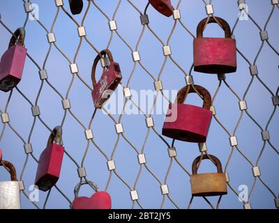 Beaucoup de cadenas d'amoureux accrochant sur les rails de pont contre le ciel bleu Banque D'Images