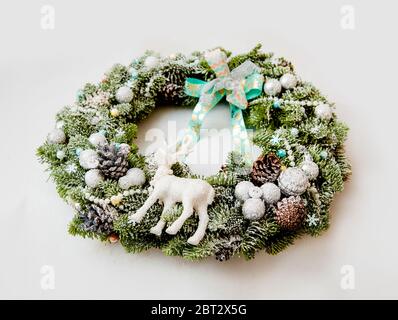 Couronne de Noël avec des cônes, des boules, arrosées de neige artificielle, décorées de rubans et une figure de cerf Banque D'Images