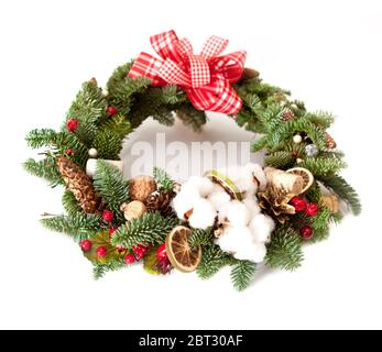 Couronne de Noël avec perles brillantes rouges, fleurs de coton et tranches d'oranges séchées Banque D'Images