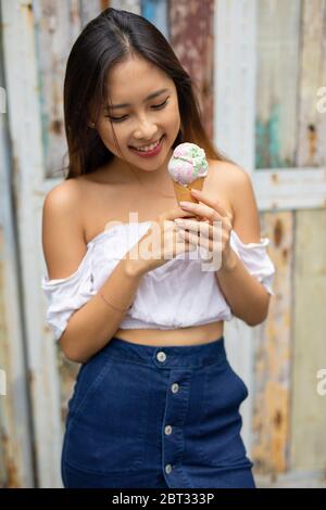 Femme souriante mangeant une glace, Bali, Indonésie Banque D'Images