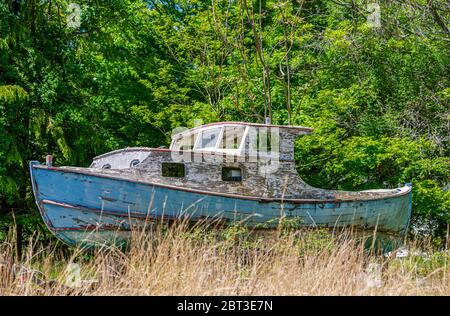 Vieux bateau à moteur en bois sur bloc avec peinture écaillée Banque D'Images