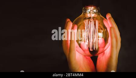 Ampoules de type Edison dans de belles mains de fille Banque D'Images