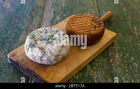 Deux fromages sur une planche en bois sur une table rustique. Fromage fumé et bleu moldy. Banque D'Images