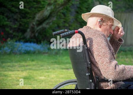 Sur son jardin patio arrière sur un chaud anglais après-midi de printemps, se rétablissant de la tête de blessure, des dommages de cerveau et de traiter la démence. Banque D'Images