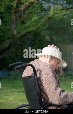 Sur son jardin patio arrière sur un chaud anglais après-midi de printemps, se rétablissant de la tête de blessure, des dommages de cerveau et de traiter la démence. Banque D'Images