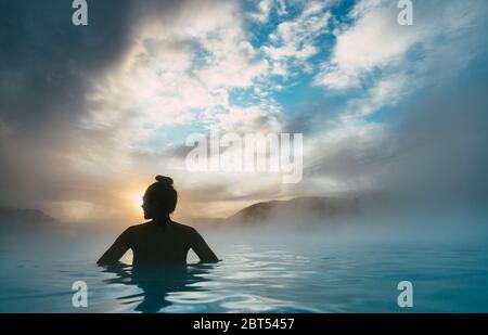 Silhouette d'une femme debout dans le lagon bleu, Islande Banque D'Images