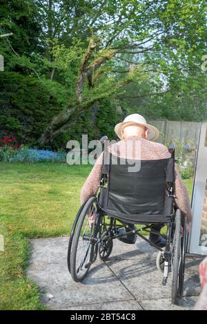 Sur son jardin patio arrière sur un chaud anglais après-midi de printemps, se rétablissant de la tête de blessure, des dommages de cerveau et de traiter la démence. Banque D'Images