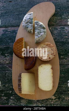 Vue de dessus de fromages variés sur un panneau rustique en bois. Fromage bleu, fromage fumé, fromage Manchego, fromage fumé. Banque D'Images