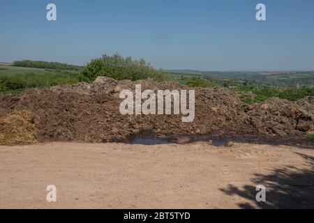 Dung Heap dans un jardin de ferme avec un ciel bleu et une vue panoramique de la campagne rurale du Devon, Angleterre, Royaume-Uni Banque D'Images