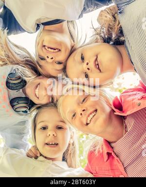 Photo de dessous de petites filles souriantes debout en cercle Banque D'Images