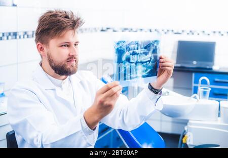 Dentiste en contrôle uniforme des résultats de rayons X. Banque D'Images