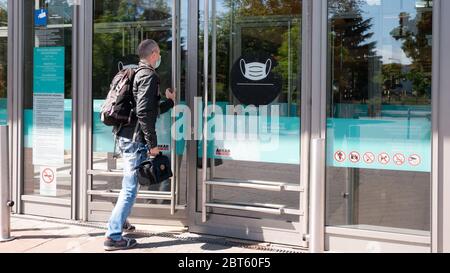 Gyor Hongrie 05 21 2020: Un homme entre dans un centre commercial dans un masque. Un panneau d'avertissement à l'entrée du centre commercial vous indique de porter un masque. Banque D'Images