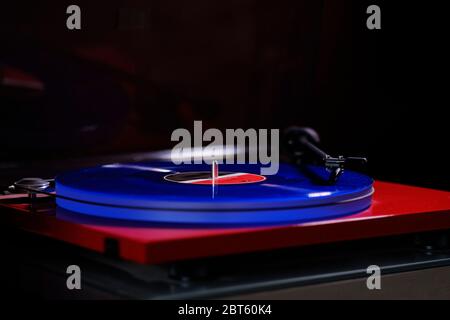 gros plan d'un album en vinyle bleu, en cours de lecture sur une platine rouge. Banque D'Images