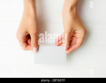 Femme tenant une carte de visite blanche entre les mains. Tamplate pour votre conception. Banque D'Images