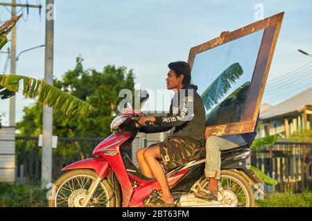 Deux hommes sur un scooter portant un grand miroir. Banque D'Images