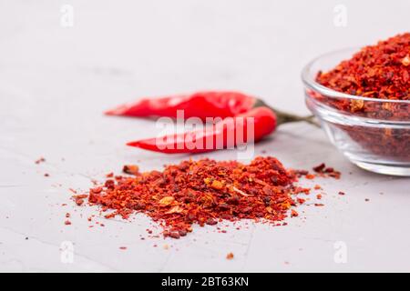 Assaisonnement Harissa dans une assiette de verre et deux piments Banque D'Images