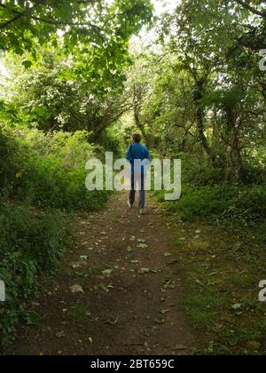 Femme locale faisant de l'exercice quotidien social distanciation marchant le long d'un sentier public pendant le verrouillage du coronavirus île d'Anglesey nord du pays de Galles Royaume-Uni Banque D'Images