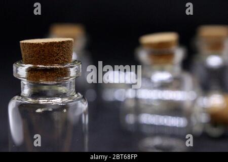 Une photographie en gros plan de bouteilles en verre vides avec bouchons en liège, sur fond noir Banque D'Images