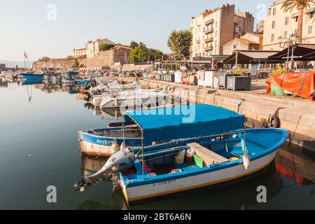 Ajaccio, France - 7 juillet 2015 : les bateaux de pêche sont amarrés dans le vieux port d'Ajaccio, île Corse, France. Les gens ordinaires marchent dans la rue Banque D'Images