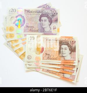 Dix billets de 10 et vingt-cinq livres sterling 20 sur fond blanc Banque D'Images