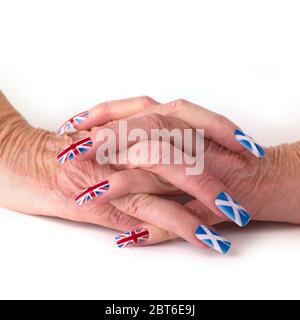 Les femmes ont une main claquée portant un Scottish Saltyre et un drapeau britannique de l'Union faux ongles Banque D'Images