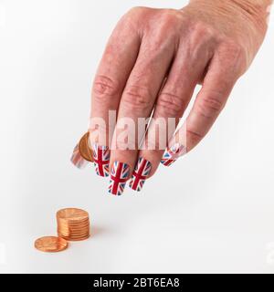 Main portant drapeau Union faux ongles tenant livre petite pièce sur fond blanc Banque D'Images