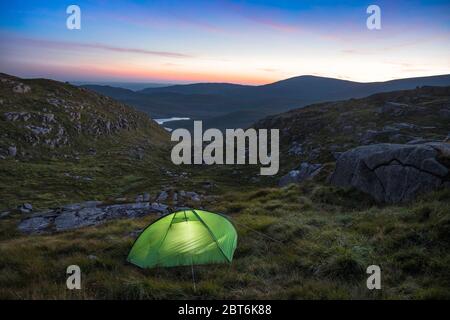 Campeur seul dans une tente d'homme près de Devil's Bowling Green, Craignaw, Galloway Forest Park Banque D'Images