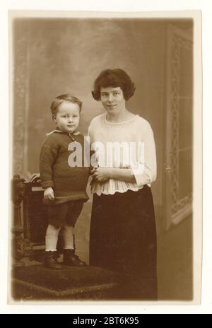 Carte postale de mère du début des années 1900 en pull à la mode crocheted, avec son fils. Vers 1921, Nelson, près de Burnley, Lancashire, Angleterre, Royaume-Uni Banque D'Images