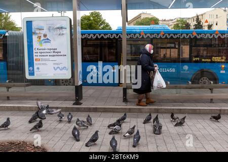 Moscou, Russie. 22 mai 2020 UNE femme portant un masque facial attend les transports publics à un arrêt de bus dans le centre de Moscou pendant le nouveau coronavirus COVID-19 épidémie et régime d'auto-isolement en Russie Banque D'Images