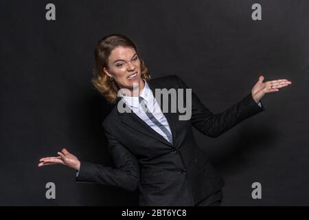 femme confuse pensant sans doute aux réponses à la question. Portrait en studio devant un arrière-plan noir. Femme d'affaires Banque D'Images