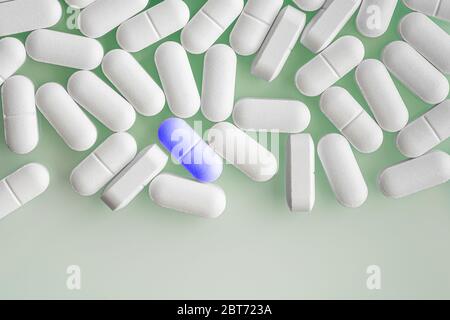Vue de dessus de beaucoup de pilules ou capsules de médicament blanc et un comprimé ou médicament de couleur bleue. Banque D'Images